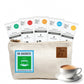 Tea Fit canvas travel pouch holding 30 assorted-flavour sachets with a cup of chai beside it