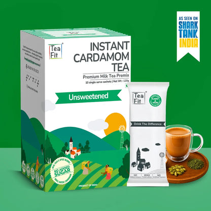 Tea Fit Instant Cardamom Tea Premium Milk Tea Premix in an Unsweetened flavor, shown as a green and white box alongside a single sachet and a prepared cup of tea on a green background.