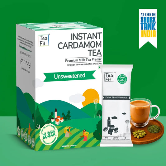 Tea Fit Instant Cardamom Tea Premium Milk Tea Premix in an Unsweetened flavor, shown as a green and white box alongside a single sachet and a prepared cup of tea on a green background.