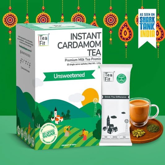 Tea Fit Instant Cardamom Tea Premium Milk Tea Premix Unsweetened box and single-serve sachet shown with a prepared cup of tea, cardamom pods, and a green decorative background with hanging lantern motifs.