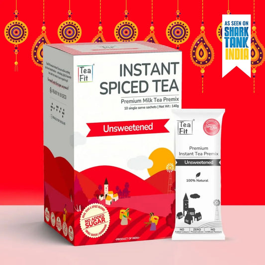 Tea Fit Instant Spiced Tea Premium Milk Tea Premix box and single serve sachet, shown on a bright red festive background with decorative hanging ornaments and a Shark Tank India badge.