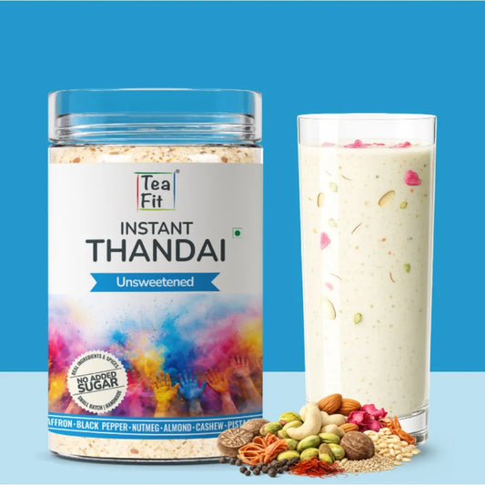 Tea Fit Instant Thandai unsweetened product jar beside a glass of prepared thandai garnished with nuts and rose petals